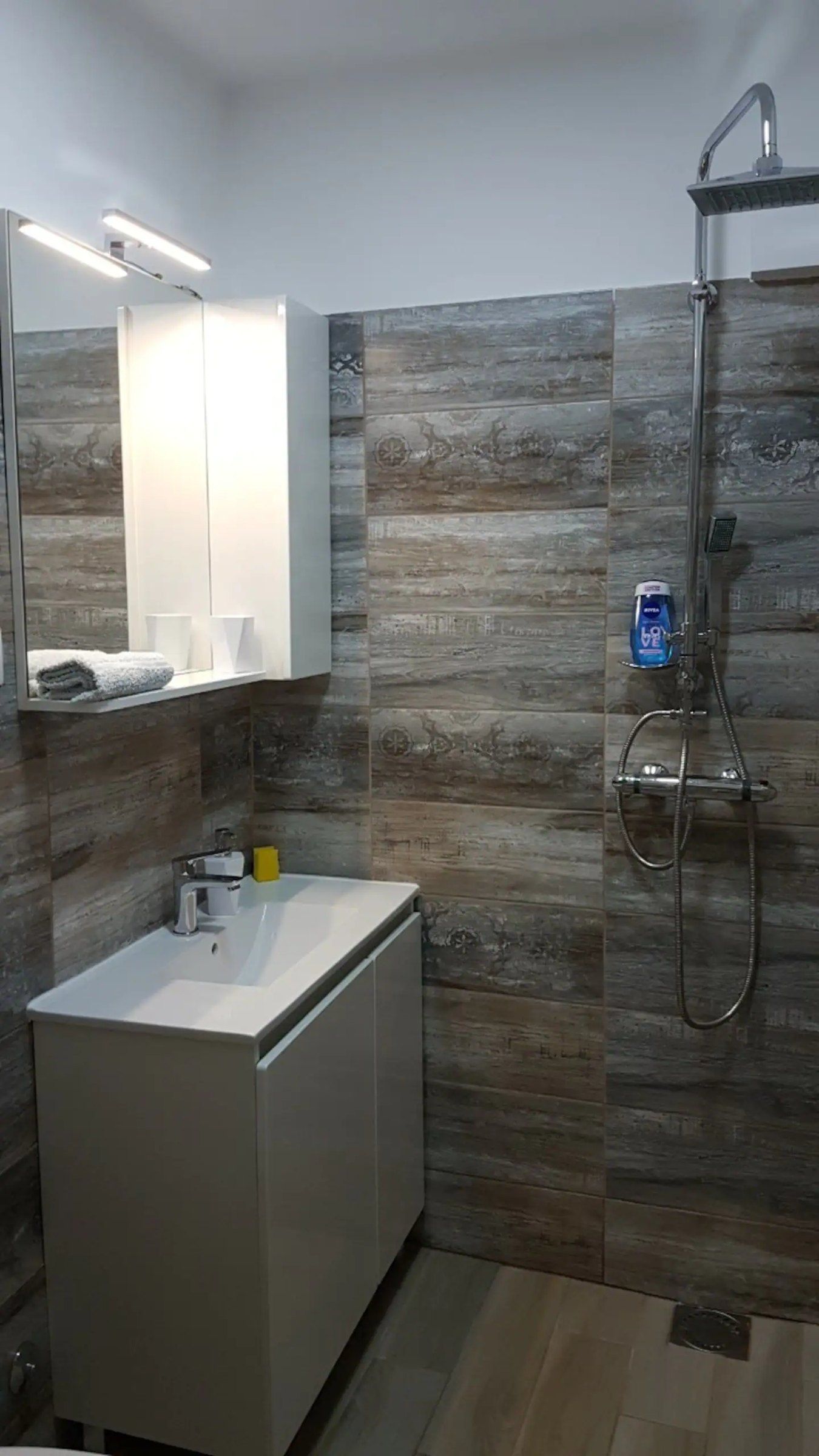 Bagno con doccia walk-in e piastrelle effetto legno