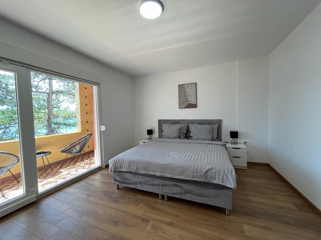 Seconda camera con letto queen size e porte a vetri sul balcone