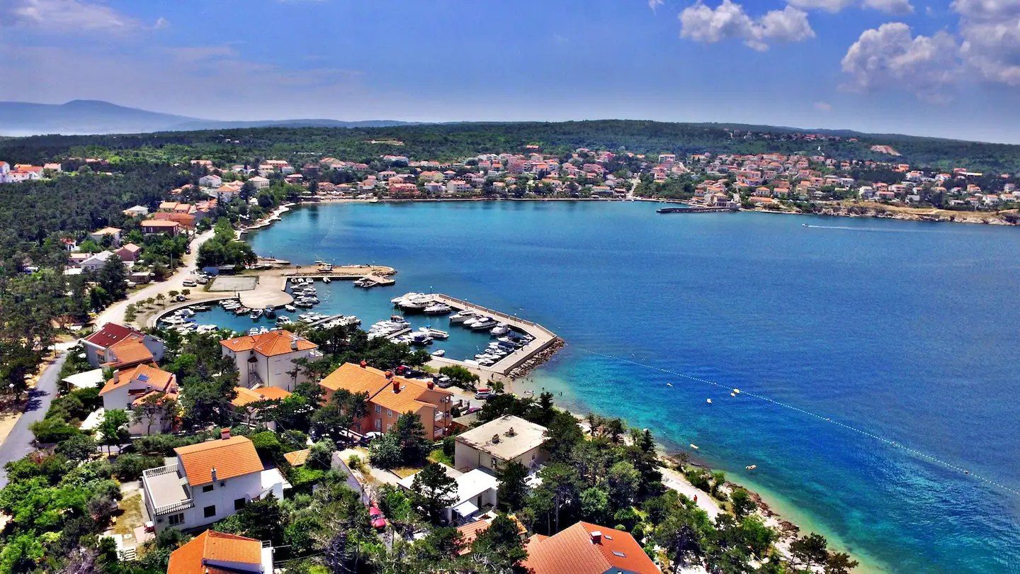 Zaljev u Šilu na otoku Krku iz zraka, s marinom, crvenim krovovima i tirkiznim morem
